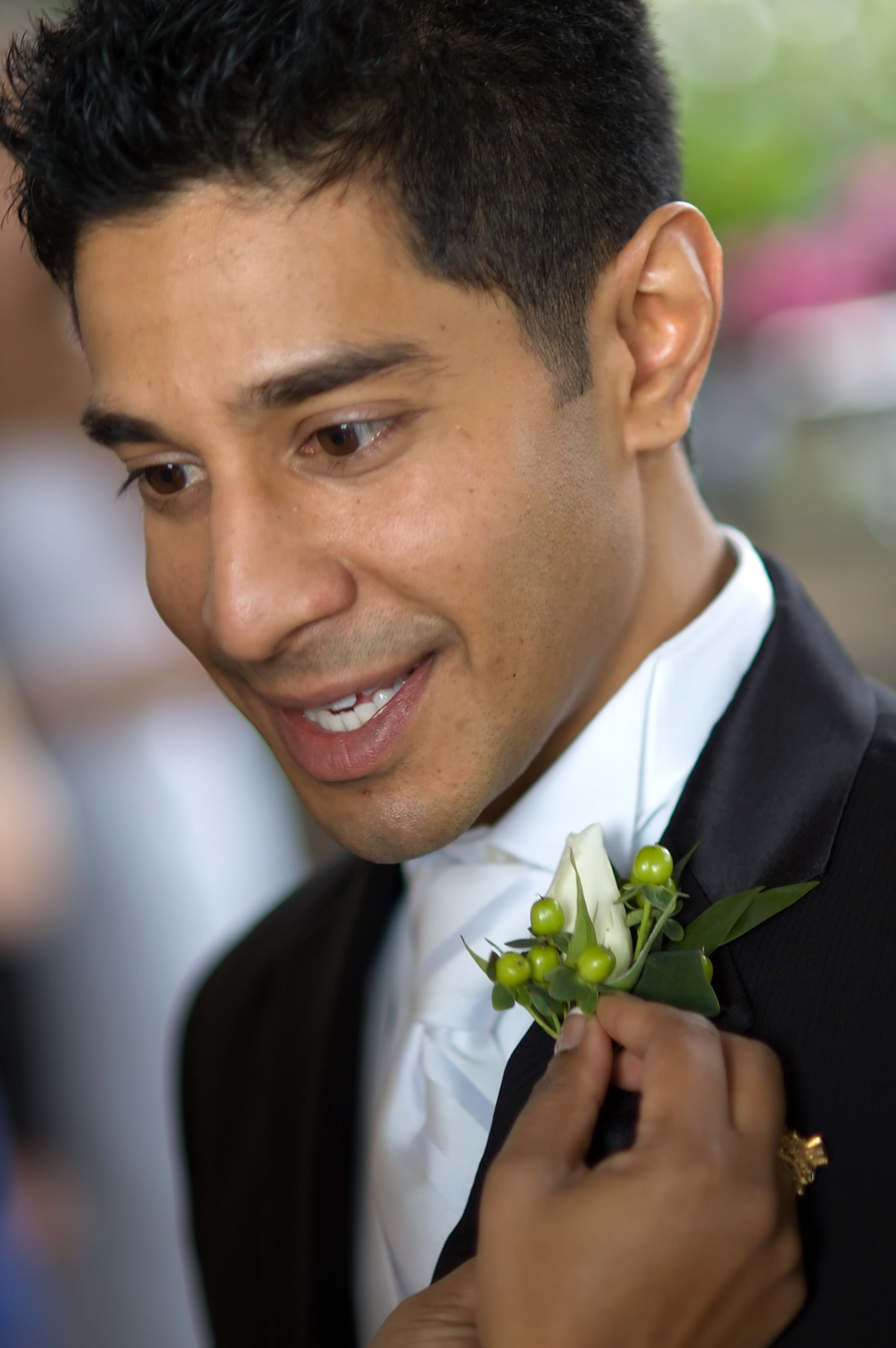 man in black suit holding bouquet of flowers